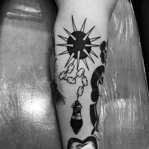 Black ink mace tattoo featuring a spiked ball on a chain with a detailed handle, symbolizing strength, power, and resilience in a bold design.