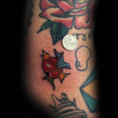 Small Magikarp tattoo with bold colors and clean lines, nestled among other classic tattoo designs for a playful contrast.