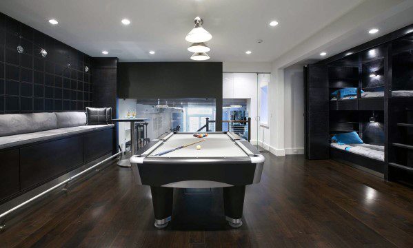 Sleek billiard room with black accents, built-in seating, and a pool table on dark wood floors.