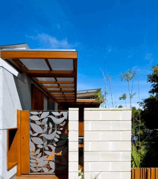 Modern building with a decorative metal screen, gate, and blue sky in the background