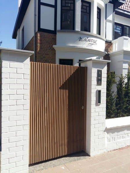 Modern white brick house with a wooden gate and "Montserrat" written above the entrance