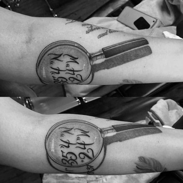 Tattoo of a magnifying glass highlighting elegant script, designed with realistic shading and depth for a bold and meaningful forearm piece.