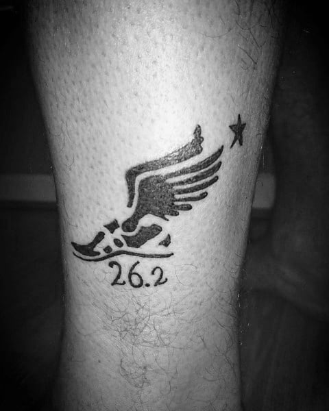 Winged running shoe tattoo with a star and “26.2” below, representing speed, aspiration, and the pride of finishing a marathon.