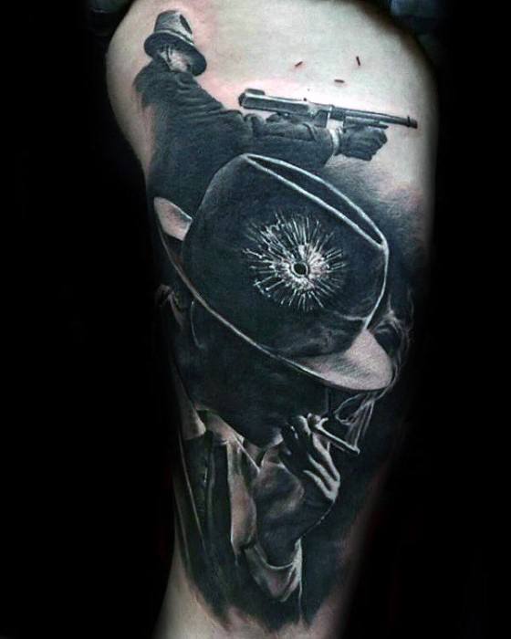 Al Capone tattoo featuring a black-and-white design with the gangster in a fedora, holding a cigar, and a dramatic scene showing a gunshot with a bullet hole in the hat.