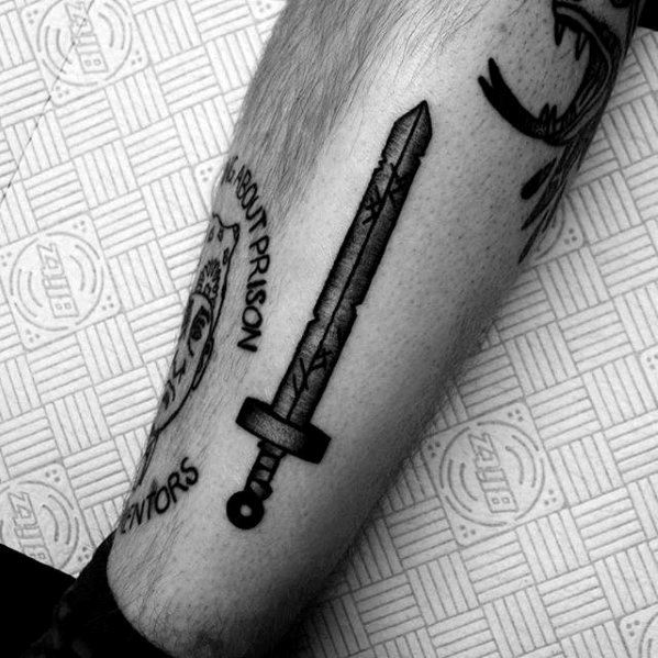 Black ink Adventure Time tattoo of Finn’s original sword with clean shading and linework, inked on the outer calf.