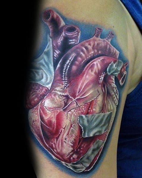 Realistic anatomical heart tattoo on the upper arm, detailed with veins and arteries, patched with silver duct tape elements.