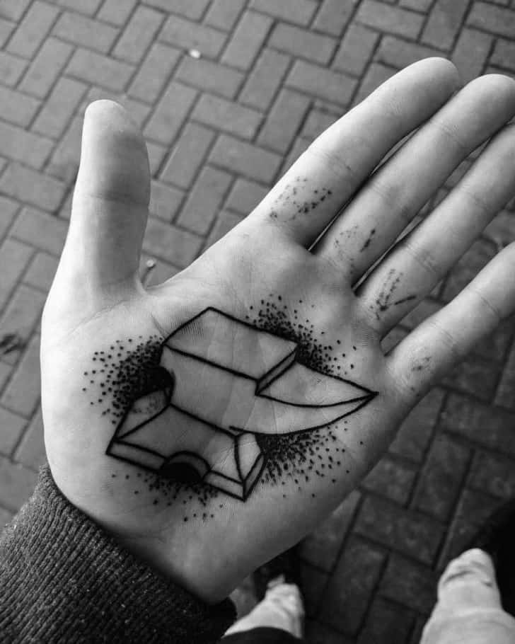Geometric-style anvil tattoo on the palm with bold black lines and surrounding dotwork shading for a textured, standout look.