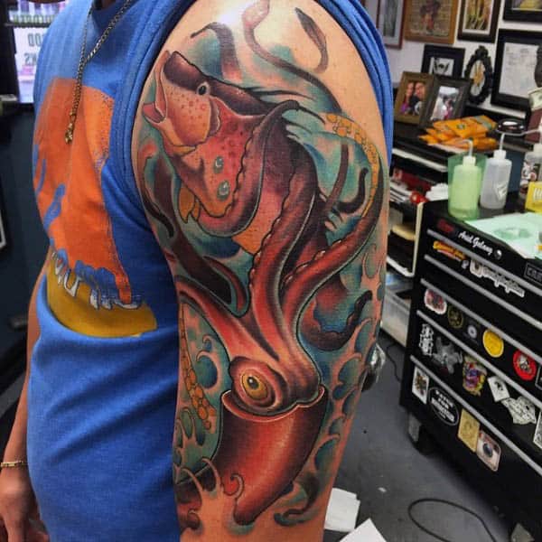 Male Arm Tattoo Of Squid With Tentacles Wrapped Around Fish