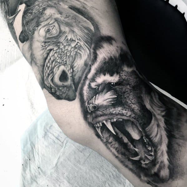 Black and grey realistic baboon tattoo with fierce expression, intense shading, and dynamic composition, creating a bold and powerful sleeve design.