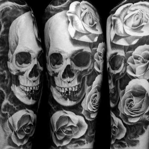 Black and grey tattoo sleeve featuring a realistic skull surrounded by detailed roses, creating a bold and dramatic design.