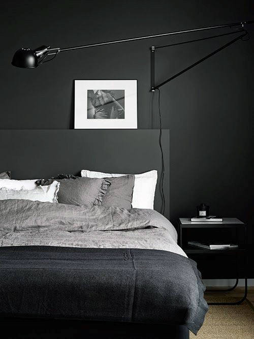 dark masculine modern bedroom with wall lamp