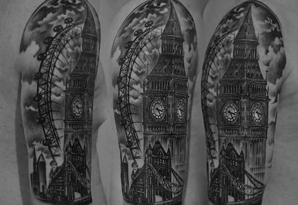 Detailed black and grey tattoo of Big Ben with the London Eye in the background, showcasing intricate shading and a dramatic cloud-filled sky on the upper arm.
