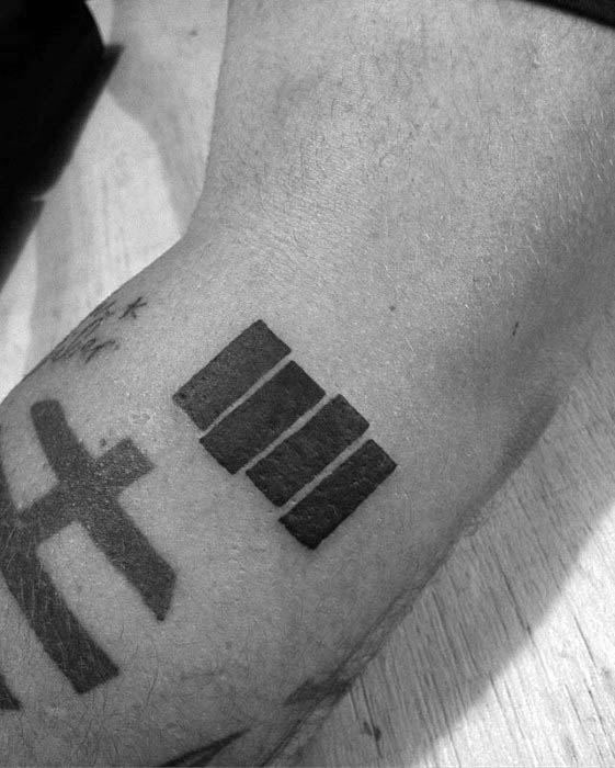 Black Flag bars tattooed on the wrist at a sharp angle, placed beside a bold black cross for a striking punk-meets-symbolic contrast.