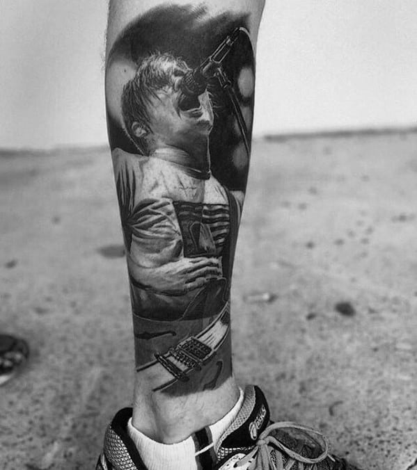 Realistic black and white tattoo of a live performance scene with Travis Barker singing into a microphone, capturing intense emotion and detailed shading.