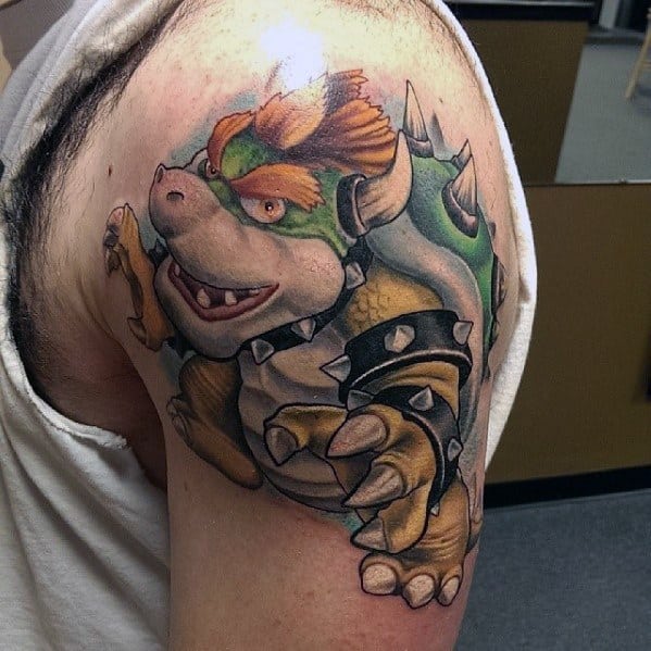Detailed Bowser tattoo on a man's shoulder featuring bold shading, vibrant colors, and a dynamic pose, creating a powerful Mario-inspired design.
