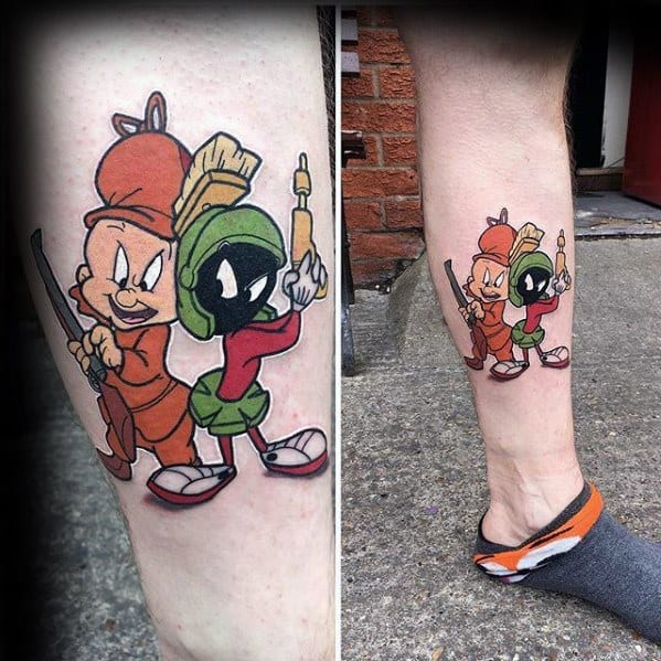 Colorful tattoo of Elmer Fudd and Marvin the Martian standing back-to-back holding cartoon weapons in classic Looney Tunes style.
