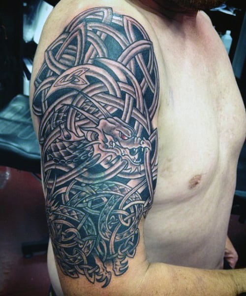Intricate dragon tattoo with Celtic design on a man's upper arm and shoulder
