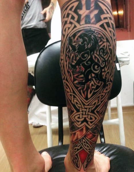 Celtic-inspired leg tattoo featuring intricate knots and a lion design on the calf
