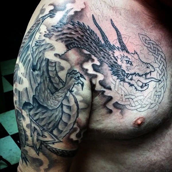 Tattoo of a dragon with smoke and knotwork on a shoulder and chest