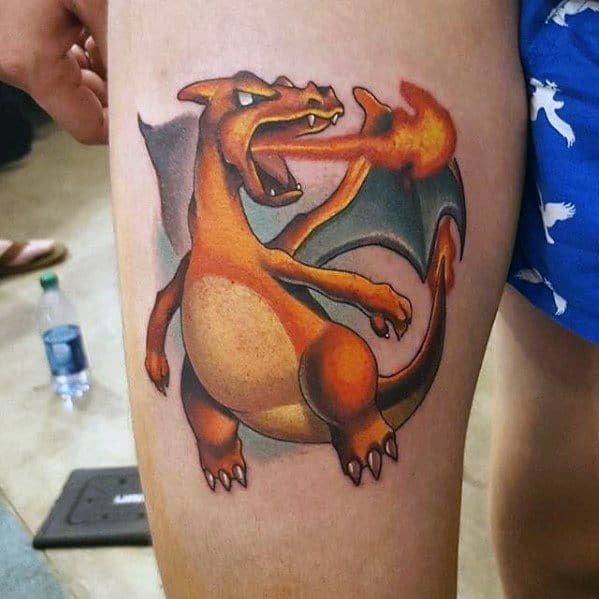Bold Charizard tattoo on thigh with fiery breath and vivid shading, featuring a classic pose and strong color contrasts.