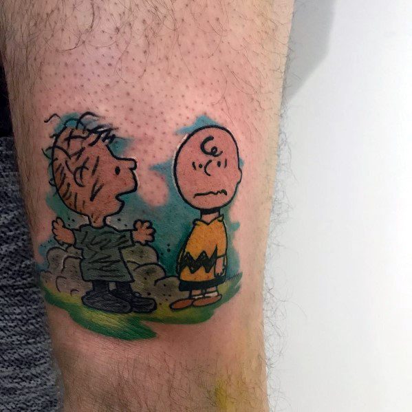 Colorful Charlie Brown and Linus tattoo, featuring a classic Peanuts moment with Linus animatedly speaking and Charlie Brown looking puzzled.
