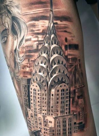 Realistic black-and-grey Chrysler Building tattoo, detailed with cityscape background and portrait elements for depth and sophistication.