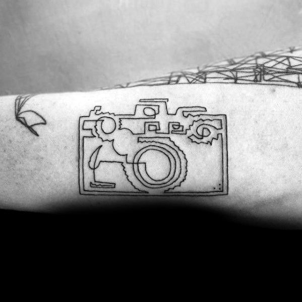 Minimalist continuous line tattoo of a vintage camera on the forearm, featuring bold black ink strokes for a sleek and artistic design.