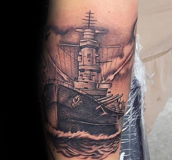 Intricate battleship tattoo on forearm, complete with clouds and ocean waves