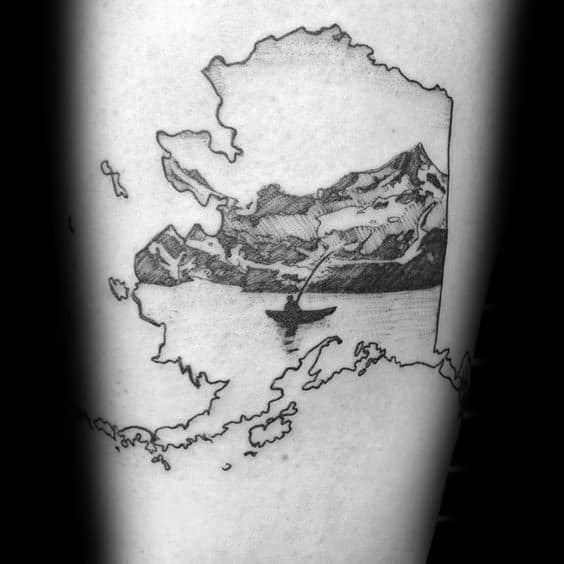 Alt text: Black and white tattoo of Alaska's outline with a mountain scene inside, featuring a canoeist paddling on a river, adding a touch of adventure.