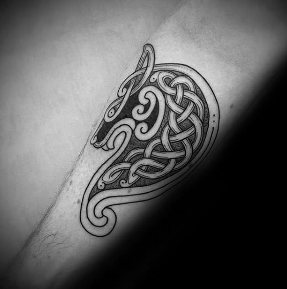 Celtic wolf head tattoo on forearm with clean black linework and intricate knot patterns forming a bold, stylized silhouette.