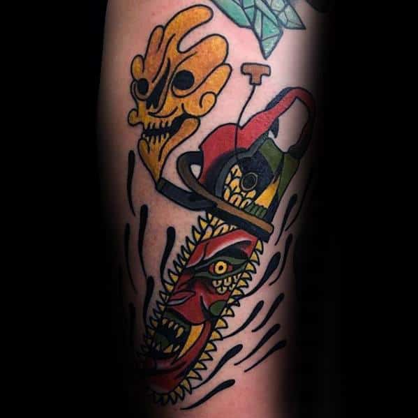 Vibrant neo-traditional tattoo of a chainsaw with a monstrous face in the blade, surrounded by abstract elements and bold black accents.