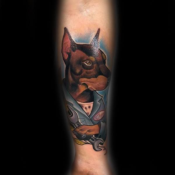 Cartoon-style Doberman tattoo dressed as a mechanic, holding a wrench, with bold outlines and vibrant colors for a fun, creative twist.