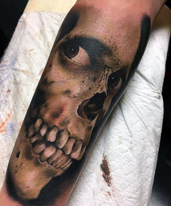 Realistic Evil Dead tattoo of a grinning skull with a single watchful eye, dark shadows, and gritty detailing for a chilling effect