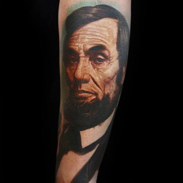 Forearm tattoo of Abraham Lincoln in formal attire with a distinguished beard
