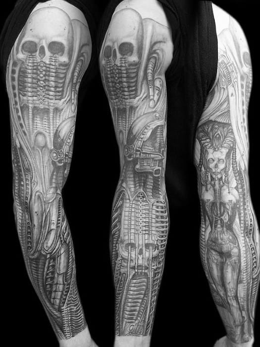 HR Giger-style full-sleeve tattoo with skeletal alien figures, biomechanical ribs, and a surreal female form integrated with machinery.
