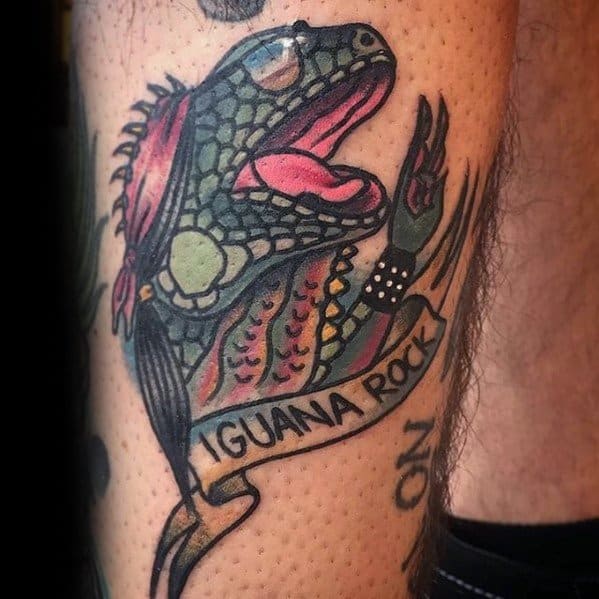 Bold neo-traditional iguana tattoo with vibrant colors, mohawk, spiked wristband, and a ribbon reading “IGUANA ROCK” for a punk vibe