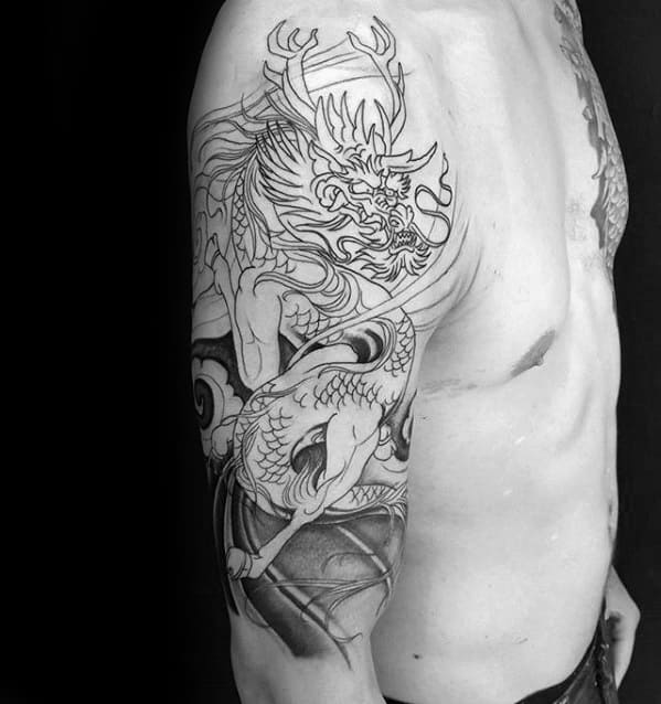 Black and grey Kirin tattoo on the upper arm and ribs, featuring fine linework, sharp scales, and fierce eyes in a dynamic traditional style.