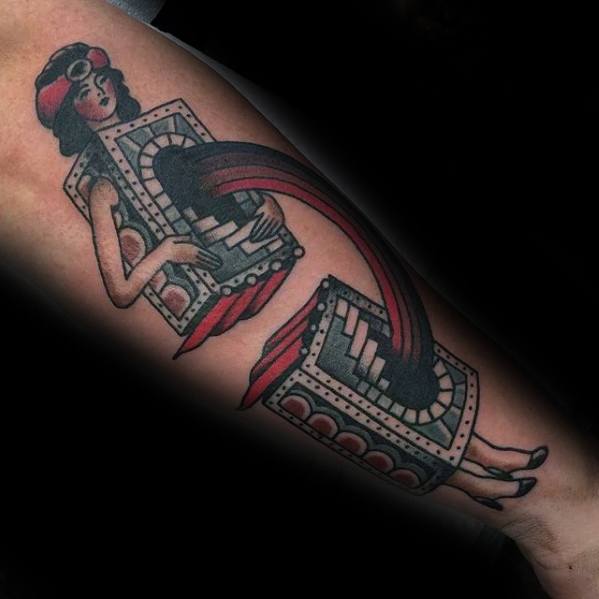Tattoo of a magician's assistant split in half, with colorful red ribbons connecting two magic boxes