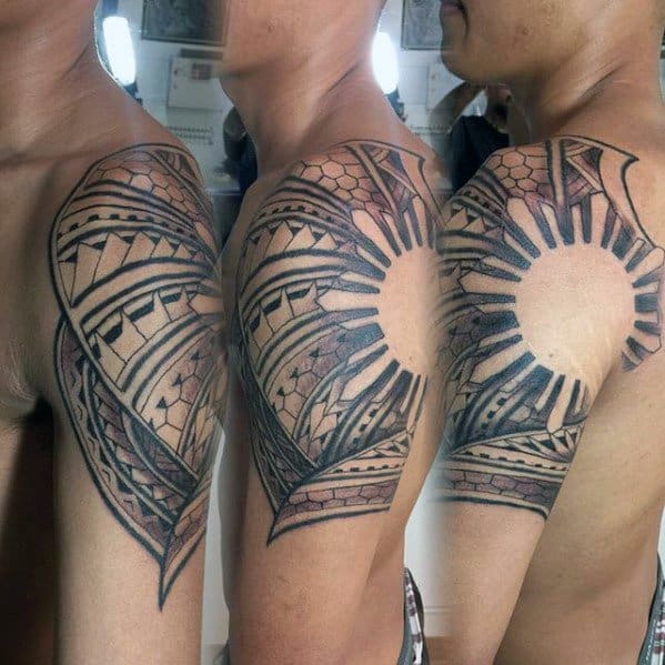 Filipino sun tattoo on the upper arm with tribal-style rays, woven bands, and curved geometric patterns forming a radiant half-sleeve design.