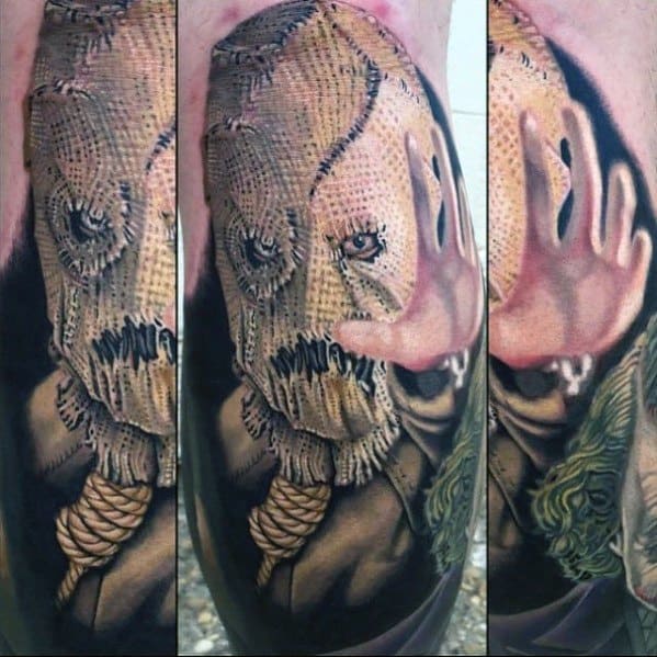 Realistic scarecrow tattoo with a burlap sack mask, stitched mouth, noose around the neck, and dramatic shading in muted tones.