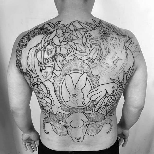 Black and white back tattoo featuring animals, flowers, and a central framed rabbit