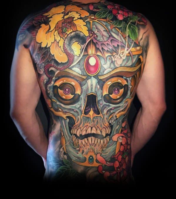 Back tattoo of a colorful, detailed skull with various flowers and a large gem