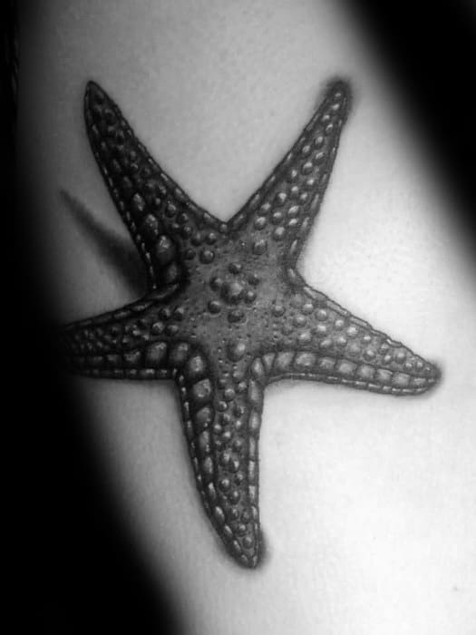 Bold black starfish tattoo with raised texture and shading, creating a realistic 3D effect on the skin.