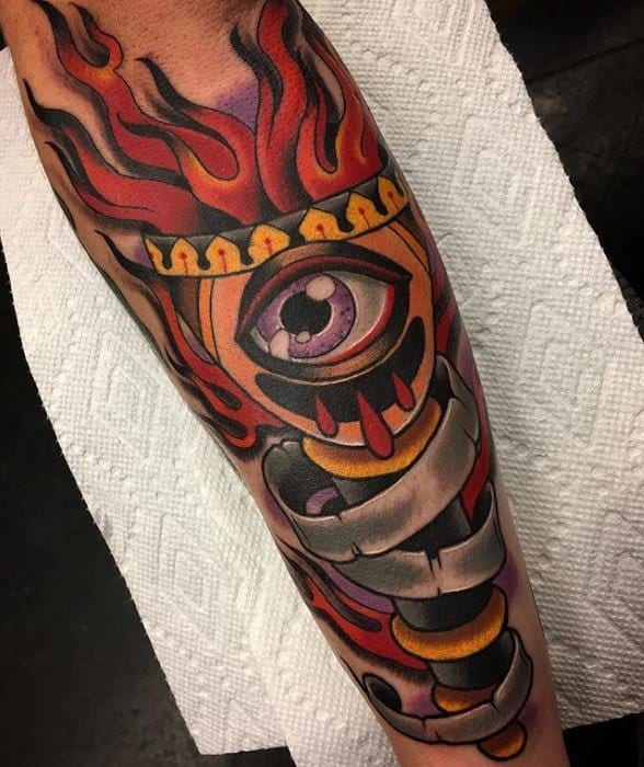 Colorful torch tattoo with a large purple eye at the center, surrounded by red flames and a twisting banner wrapping the handle.