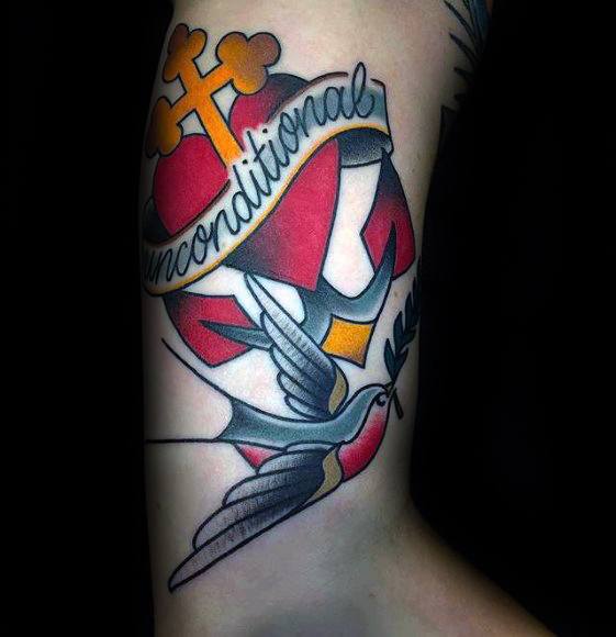 Tattoo of a heart, cross, ribbon "unconditional," and bird holding an olive branch