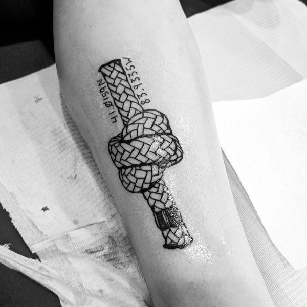 Intricate rope knot coordinate tattoo on the forearm with bold black detailing, symbolizing strength, connection, and a meaningful location.