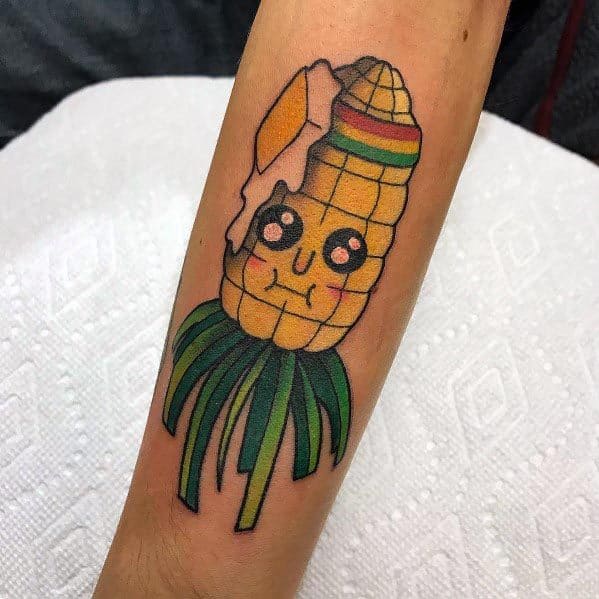 Colorful tattoo of a cute, cartoon-style corn cob with a melting butter top, expressive eyes, and green husks resembling tentacles.