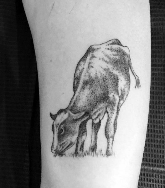 Fine line tattoo of a cow grazing on grass, using dotwork shading for a soft, realistic look on the upper arm.