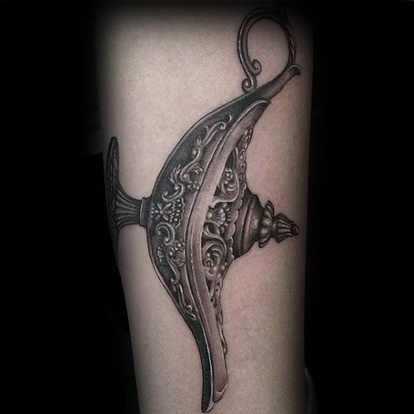 Black and gray ornate Genie lamp tattoo on forearm
