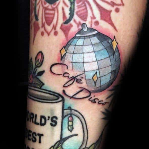Vintage-style tattoo featuring a disco ball with 'Café Disco' text, surrounded by colorful elements for a fun and nostalgic design.